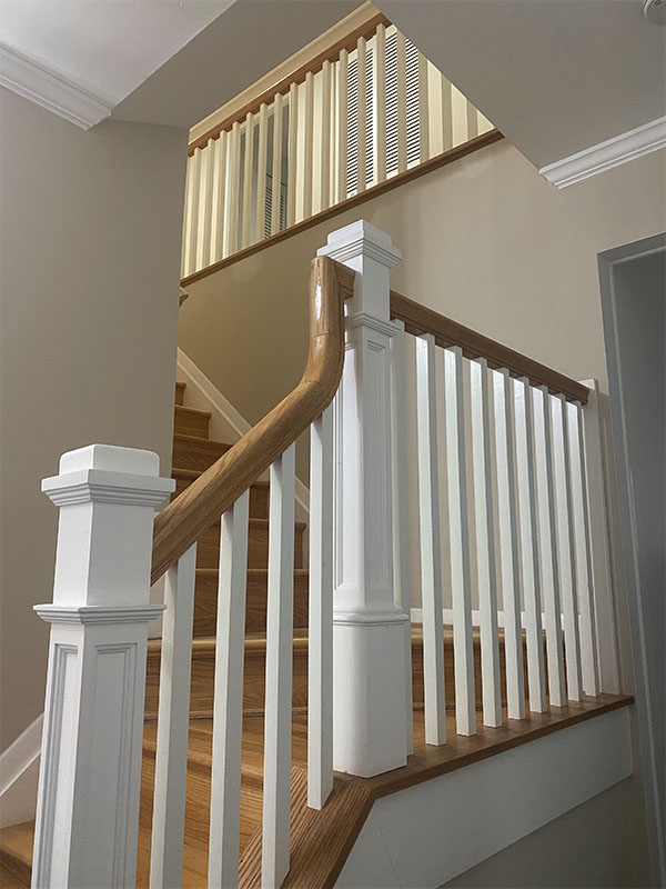 Custom staircase with light wood finish & white paint.