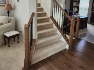 Staircase with carpeted steps and new wood and metal railings by Darby Star Renovations.